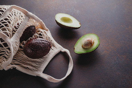 Avocado hass in an eco net bag on a table