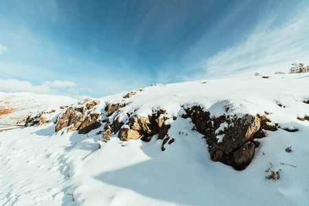 Snow covered rocks on the mountain with blue sky