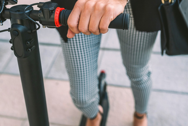 Unrecognizable businesswoman with e-scooter outdoors