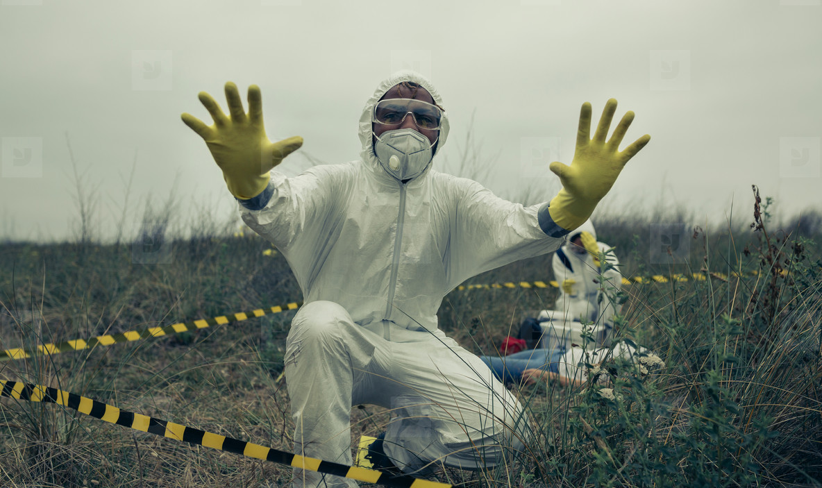 Man with bacteriological protective suit prohibiting entering cordoned off area