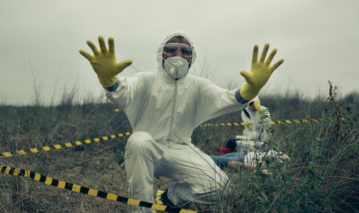 Man with bacteriological protective suit prohibiting entering cordoned off area