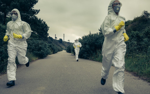 People with bacteriological protection suits running