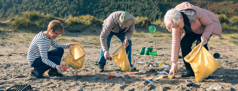 Senior volunteers cleaning the beach