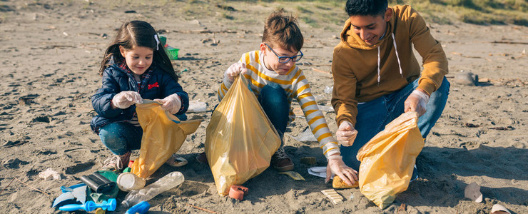 Young volunteers cleaning the beach