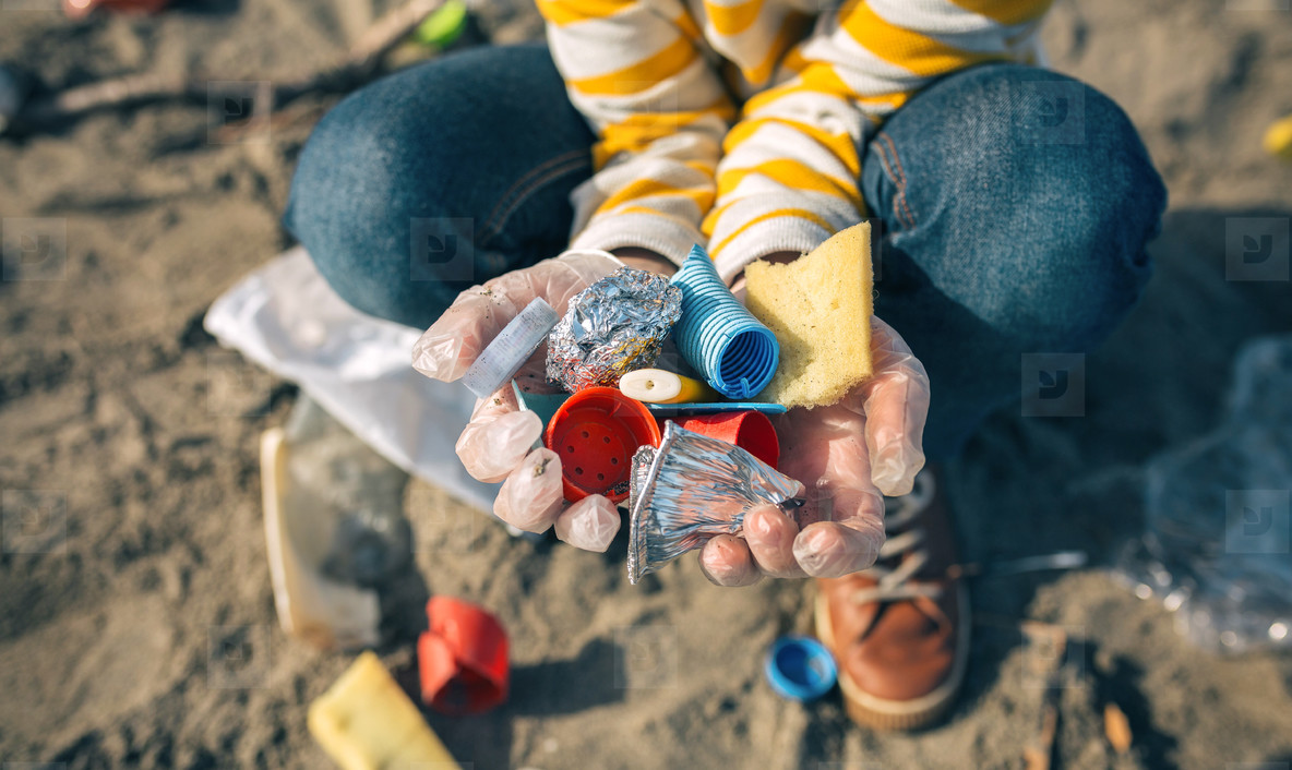 Child hands with garbage from the beach