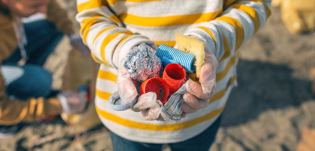 Boy hands with garbage from the beach