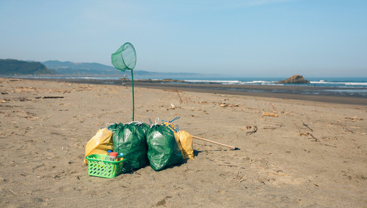 Garbage bags and utensils on the beach