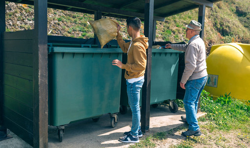 Men throwing garbage to container