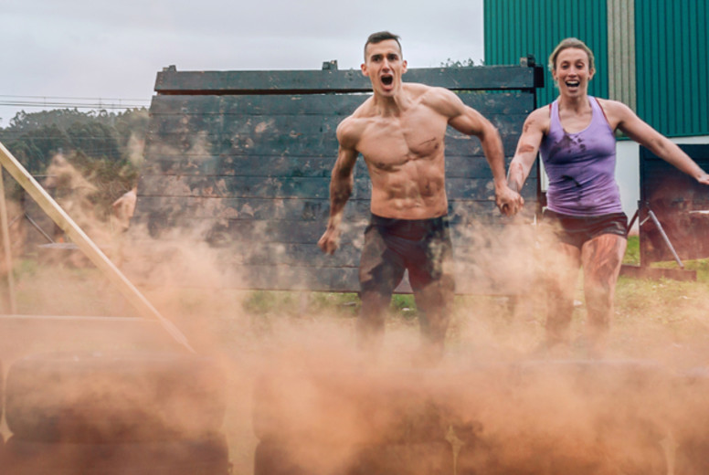 Athletes jumping finish line of an obstacle course