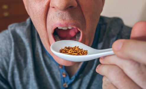 Man eating a spoonful of worms