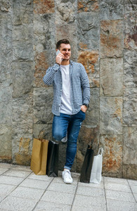 Young man with shopping bags and mobile