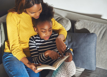 Black mom learning daughter to read