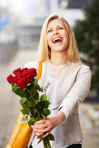 Professional woman with head tilted holding roses