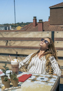 Woman with sunglasses sunbathing on the terrace