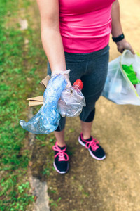 Unrecognizable girl showing garbage she has collected