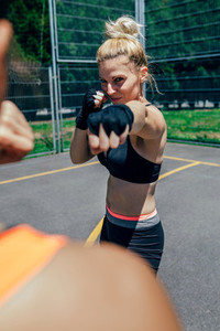 Sportswoman training boxing with her trainer