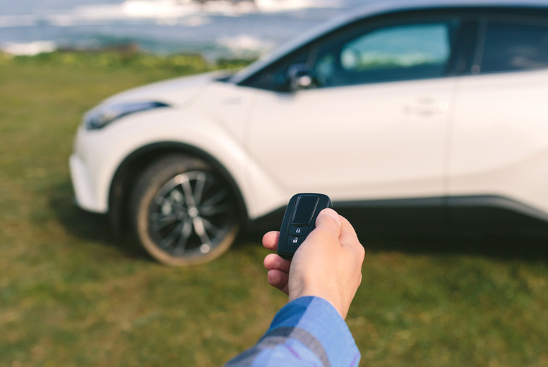 Man closing the car door with remote control
