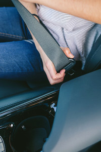 Young womans hand putting on seatbelt