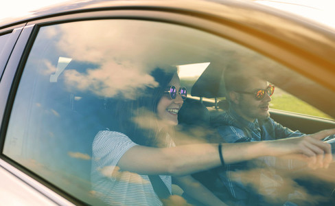 Young man driving a car with his girlfriend