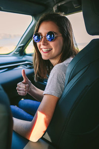 Girl doing thumbs up in the car
