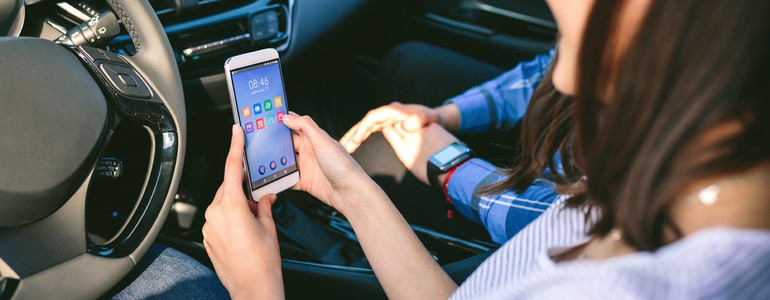 Girl and boyfriend using mobile in the car