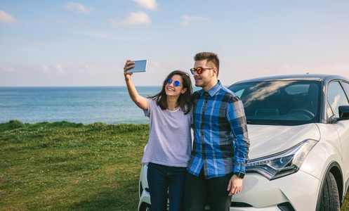 Young couple doing a selfie on the car