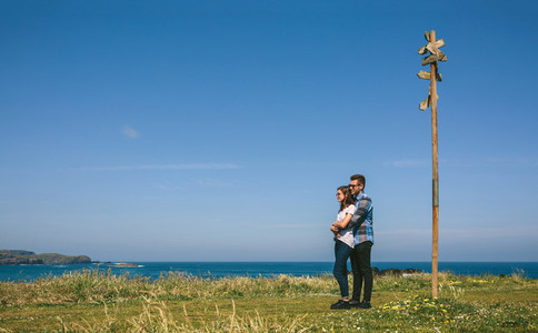 Couple embraced by a direction sign