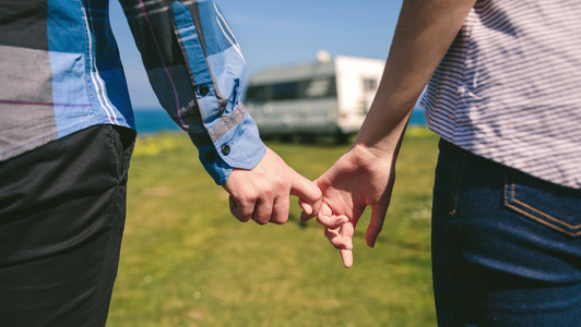 Unrecognizable couple holding hands with hooked fingers