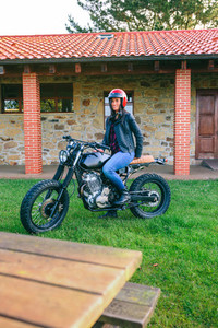 Woman with helmet riding custom motorbike