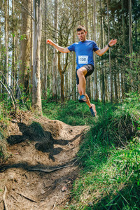 Man jumping participating in trail race