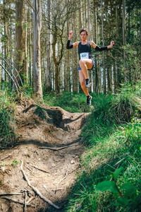 Woman jumping participating in trail race
