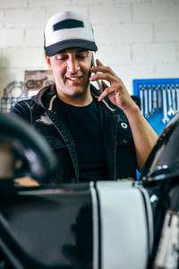 Mechanic talking phone while fixing motorbike