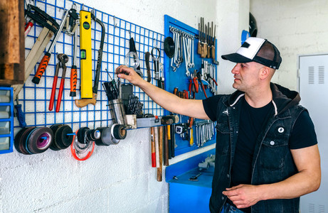 Mechanic in his workshop taking tools