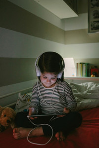 Girl with headphones looking at the tablet