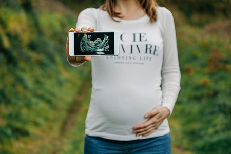 Pregnant showing ultrasound on the mobile