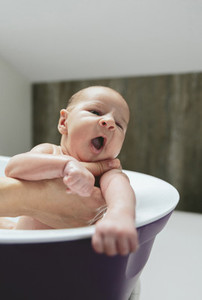 Newborn yawning in the bathtub