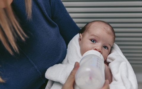 Baby taking feeding bottle