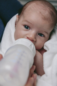 Baby taking feeding bottle