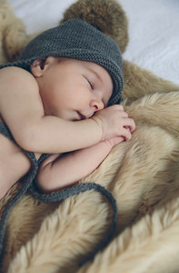 Baby girl with pompom hat sleeping