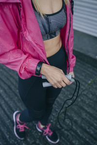 Young woman with sportswear and jump rope