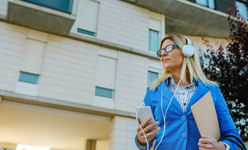 Businesswoman with headphones and mobile