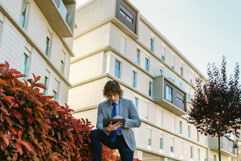 Businessman working with the tablet in the street