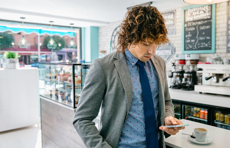Businessman looking mobile in a cafe