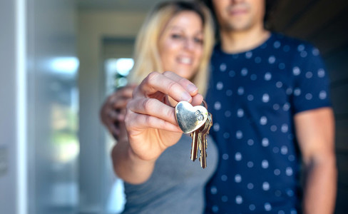 Couple showing the keys of their house