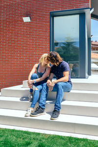 Couple kissing in front new house