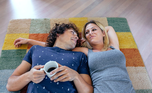 Couple resting lying on the carpet