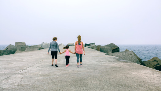 Back view of three female generations walking
