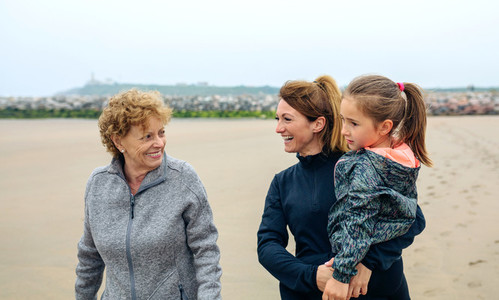 Three generations female walking on the beach