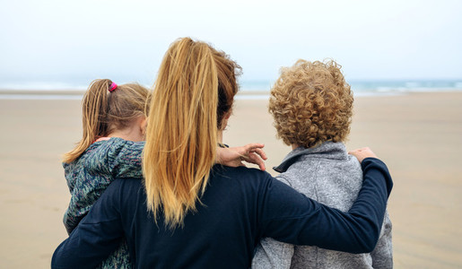Back view of three generations female looking at sea
