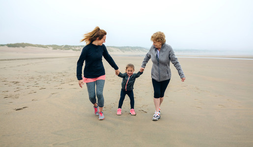 Three generations female running on the beach